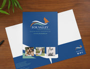 Blue pocket folder with healthcare logo and branding printed on the cover and pockets.