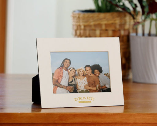 Personalized cream mat board frame with gold foil logo imprint.