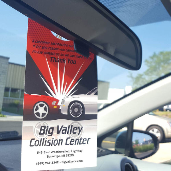 Rearview mirror hanger hangs in a car, advertising a collision center