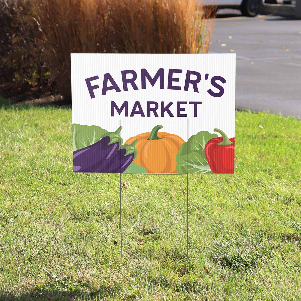 Custom printed yard sign for a farmers market set in grass with metal stakes.