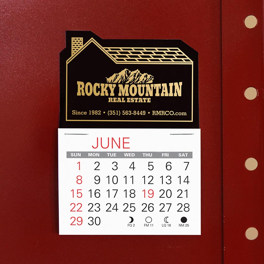 Black house-shaped calendar with real estate company logo stamped in gold foil