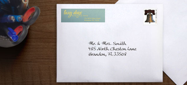 A handwritten address on a greeting card envelope, complete with return address label and first class stamp