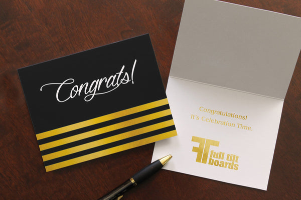 Black congrats card with one card closed, showing the cover design. The other card is open, showing a congratulations sentiment and logo stamped in gold foil.