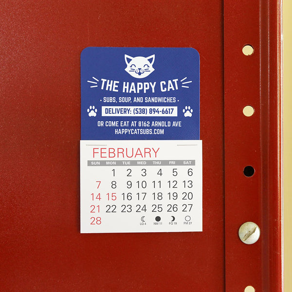 Small blue calendar advertising a small restaurant sticks to a red metal cabinet