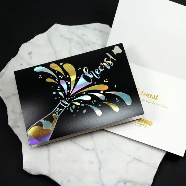 Black new years card with gold and silver foil champagne bottle design. Inside of card shows a gold foil stamped sentiment and company logo imprint.