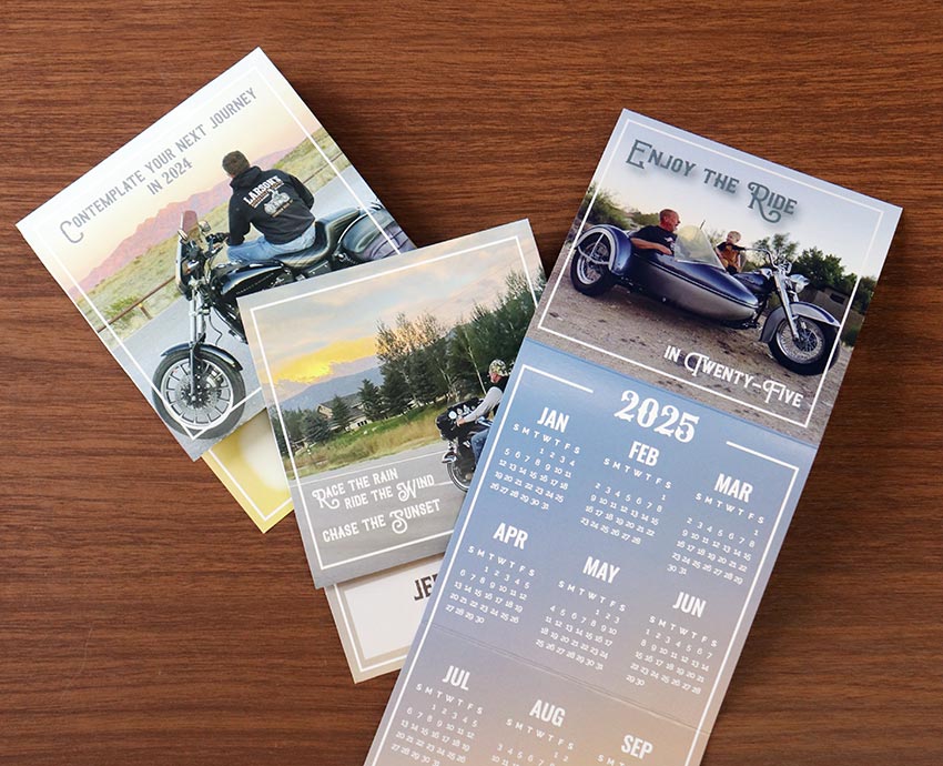 Three custom trifold calendars with motorcycle pictures above the calendar.