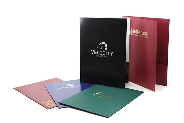 Five pocket folders of various colors, each with a company logo foil stamped on the front cover.