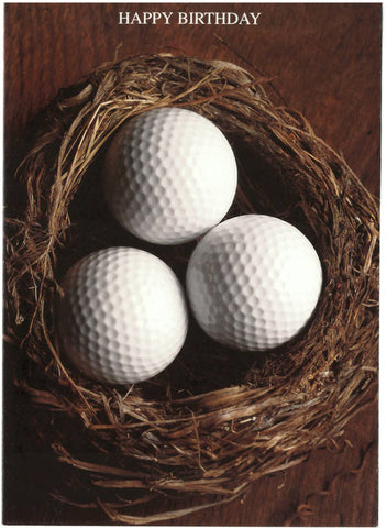 A trio of golf balls sit in a birds nest with the words Happy Birthday above the nest